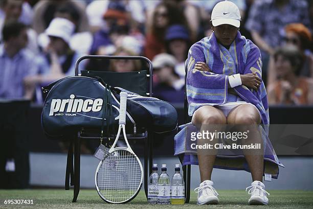 Ai Sugiyama of Japan wraps a towel around herself during the changeover for her Women's Singles third round match Monica Seles at the Wimbledon Lawn...