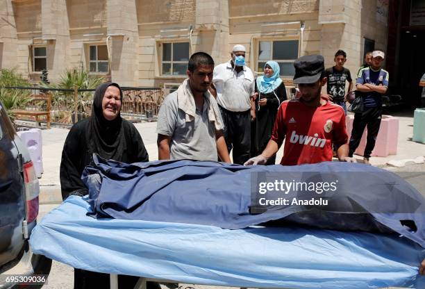 Dead body, found left in a street, is being brought to Hospital of Mosul by members of Iraqi army in Mosul, Iraq on June 12, 2017. Civilians who fled...