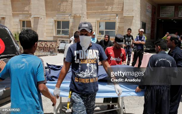 Dead body, found left in a street, is being brought to Hospital of Mosul by members of Iraqi army in Mosul, Iraq on June 12, 2017. Civilians who fled...