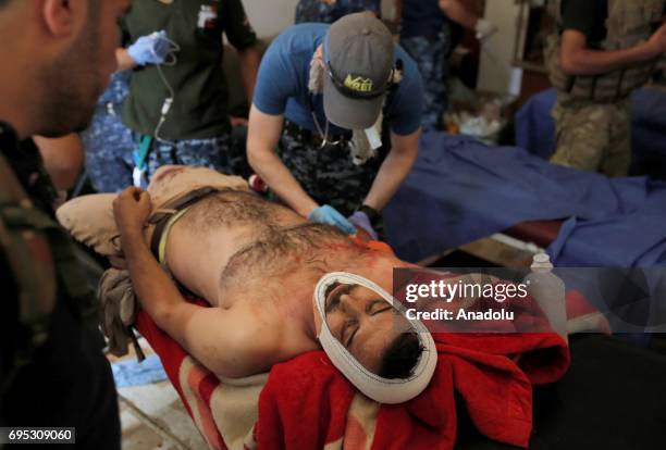 An injured man named Yaser Cabbar receives medical treatment at Hospital of Mosul by members of Iraqi army in Mosul, Iraq on June 12, 2017. Civilians...