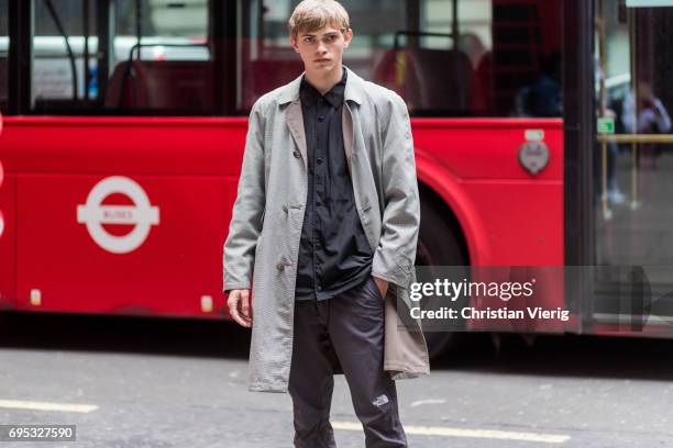 Guest wearing a grey trench coat during the London Fashion Week Men's June 2017 collections on June 12, 2017 in London, England.