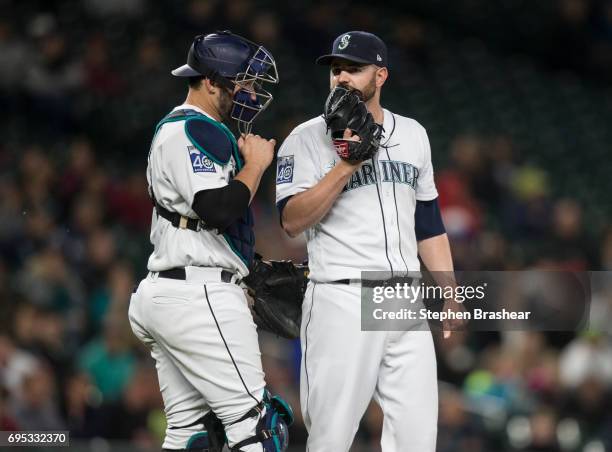 Catcher Mike Zunino of the Seattle Mariners and relief pitcher Marc Rzepczynski of the Seattle Mariners meet at the pitcher's mound during a game...