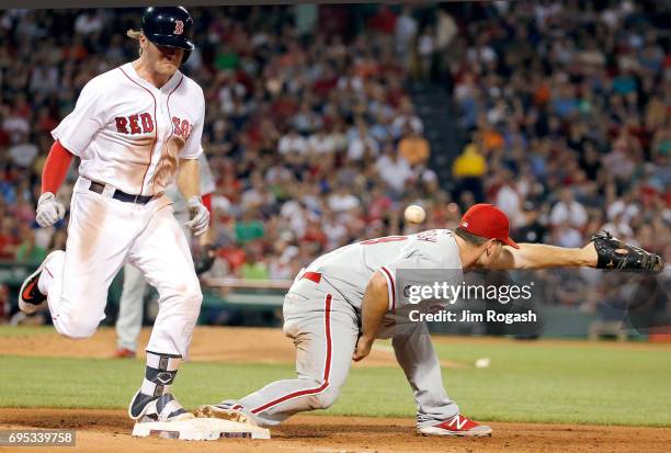 Josh Rutledge of the Boston Red Sox reaches base on a fielder's choice as Tommy Joseph of the Philadelphia Phillies is unable to control the ball in...