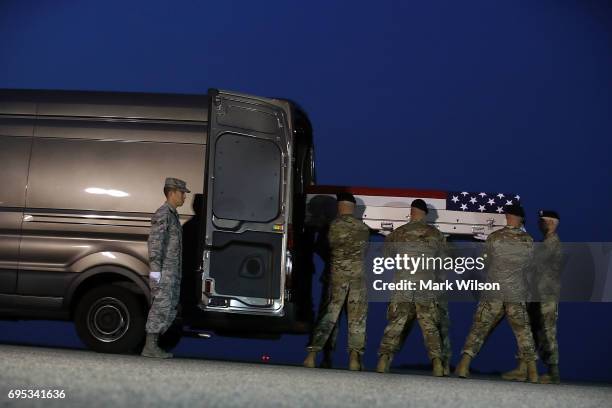 Army carry team moves the transfer case containing the remains of U.S. Army Sgt. Eric M. Houck, during a dignified transfer at Dover Air Force Base,...