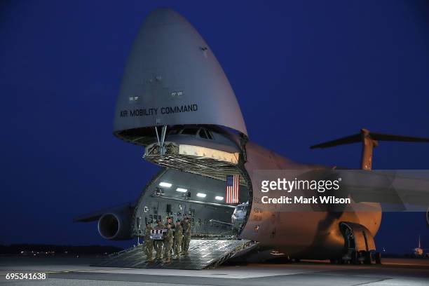 Army carry team moves the transfer case containing the remains of U.S. Army Sgt. William M. Bays, during a dignified transfer at Dover Air Force...