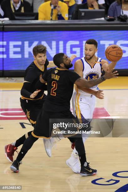 Stephen Curry of the Golden State Warriors looks to pass the ball against Kyrie Irving and Kyle Korver of the Cleveland Cavaliers in Game 5 of the...