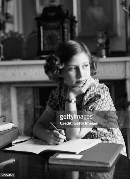 Princess Margaret Rose, younger daughter of King George VI and Queen Elizabeth, studies in the schoolroom June 22, 1940 at Windsor Castle. Buckingham...