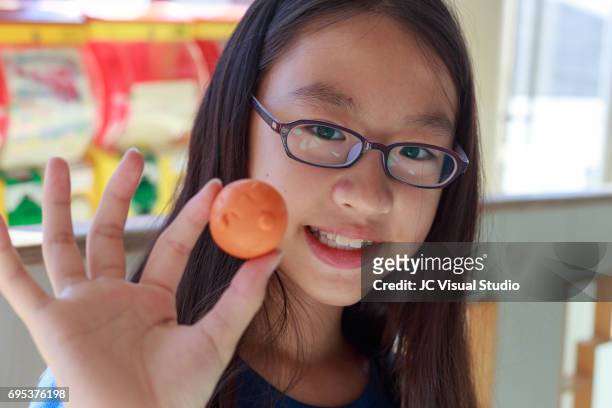 girl and her new capsule toy (japanese: gashapon) - asian child with new glasses ストックフォトと画�像