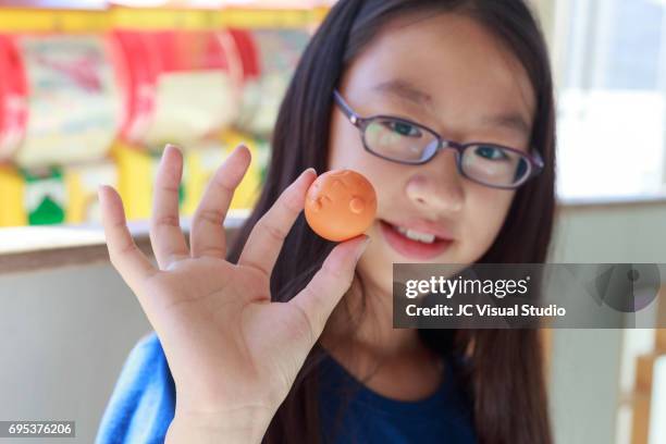 girl and her new capsule toy (japanese: gashapon) - asian child with new glasses ストックフォトと画�像