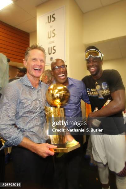 Steve Kerr, Mike Brown and Draymond Green of the Golden State Warriors celebrate with the Larry O'Brien Trophy in the locker room after winning the...