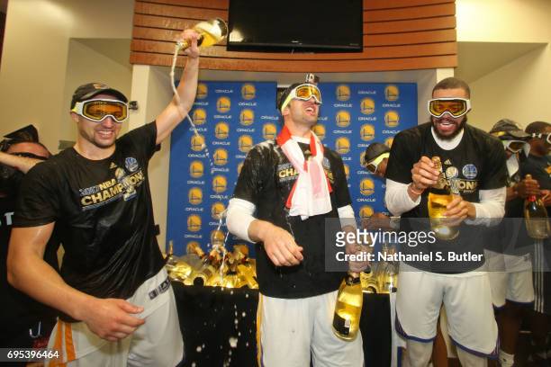 Klay Thompson, Zaza Pachulia and JaVale McGee of the Golden State Warriors celebrate in the locker room after winning the NBA Championsip in Game...