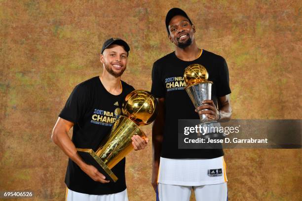 Stephen Curry and Kevin Durant of the Golden State Warriors poses for a portrait with the Larry O'Brien Trophy after defeating the Cleveland...