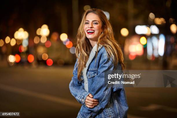 retrato de mujer feliz de pie en el camino en la noche - chaqueta tejana imágenes fotografías e imágenes de stock