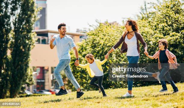 happy family running in the park - running side view stock pictures, royalty-free photos & images