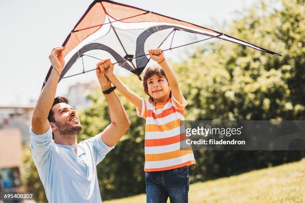 father and son flying a kite - flying dad son stock pictures, royalty-free photos & images