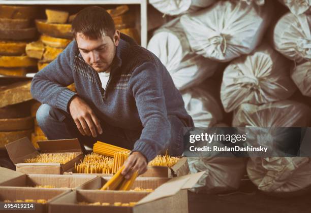 packager packing church candles into boxes at warehouse. - beeswax stock pictures, royalty-free photos & images