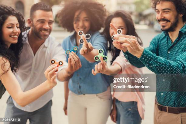friends playing with fidget spinners - fidget spinner stock pictures, royalty-free photos & images