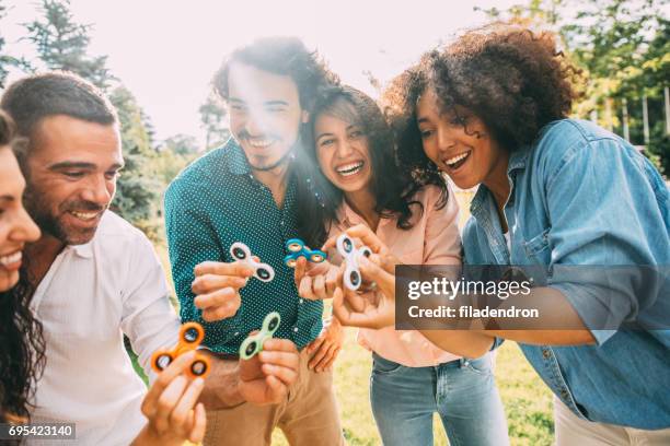 freunde spielen mit fidget spinner - fidget spinner stock-fotos und bilder