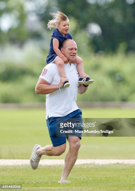 Mike Tindall carries daughter Mia Tindall on his shoulders as they attend the Maserati Royal Charity Polo Trophy Match during the Gloucestershire...