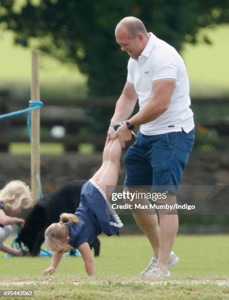 Mike Tindall plays wheelbarrows with daughter Mia Tindall as they attend the Maserati Royal Charity Polo Trophy Match during the Gloucestershire...