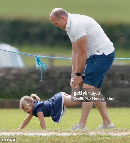 Mike Tindall plays wheelbarrows with daughter Mia Tindall as they attend the Maserati Royal Charity Polo Trophy Match during the Gloucestershire...