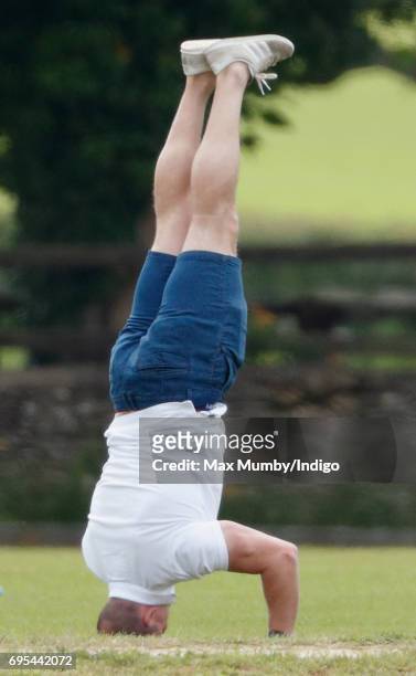 Mike Tindall does a headstand as he attends the Maserati Royal Charity Polo Trophy Match during the Gloucestershire Festival of Polo at the Beaufort...