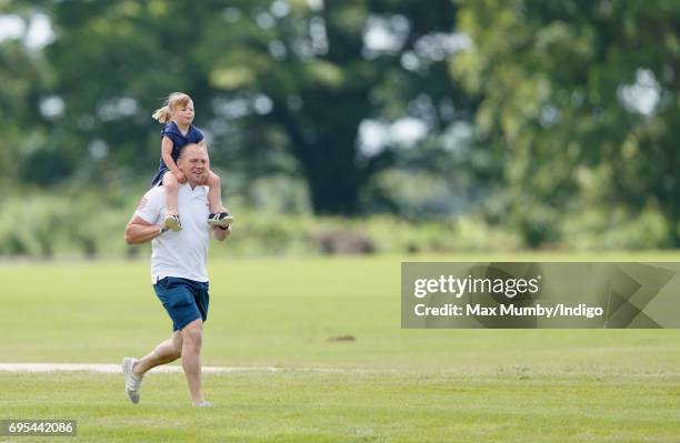 Mike Tindall carries daughter Mia Tindall on his shoulders as they attend the Maserati Royal Charity Polo Trophy Match during the Gloucestershire...