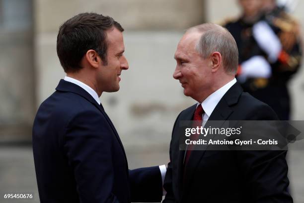 French President Emmanuel Macron welcomes Russian President Vladimir Putin prior to their meeting at 'Chateau de Versailles' on May 29, 2017 in...