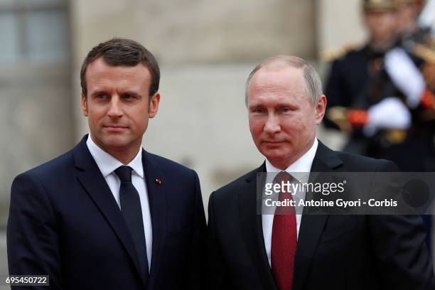French President Emmanuel Macron welcomes Russian President Vladimir Putin prior to their meeting at 'Chateau de Versailles' on May 29, 2017 in...