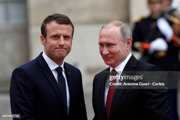 French President Emmanuel Macron welcomes Russian President Vladimir Putin prior to their meeting at 'Chateau de Versailles' on May 29, 2017 in...