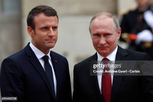 French President Emmanuel Macron welcomes Russian President Vladimir Putin prior to their meeting at 'Chateau de Versailles' on May 29, 2017 in...