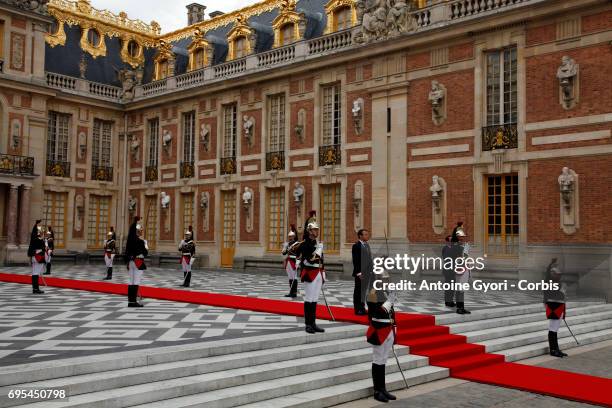 French President Emmanuel Macron wallks on the red carpet to welcome Russian President Vladimir Putin prior to their meeting at 'Chateau de...