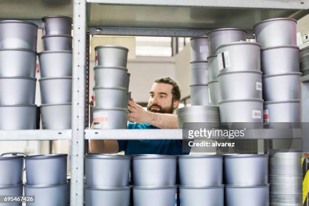 worker taking ink cans from shelf at printing press - metallic ink stock pictures, royalty-free photos & images