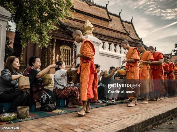 alms giving ceremony in luang prabang laos - alms stock pictures, royalty-free photos & images