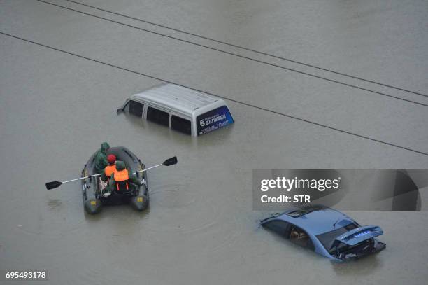 This photo taken on June 12 shows submerged cars in a flooded street in Guiyang, in China's southwest Guizhou province. - Sudden heavy rains flooded...