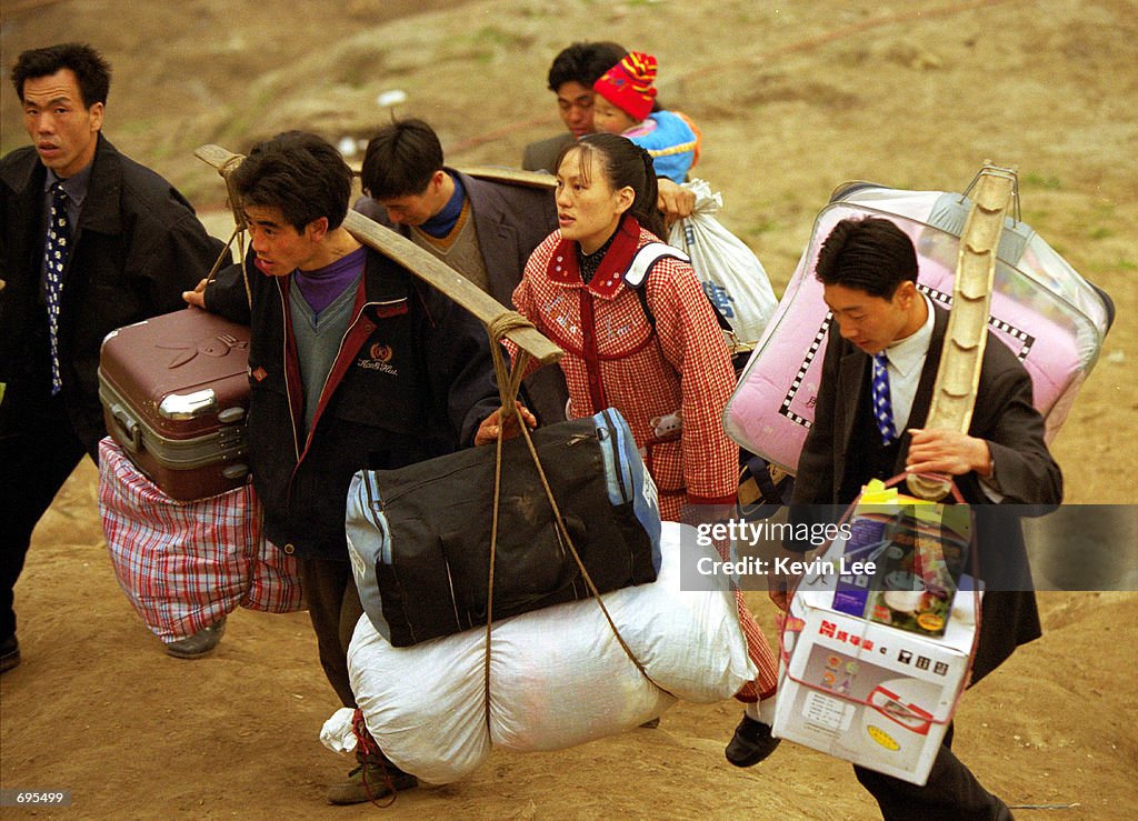 Chinese men tie luggages on top of bus