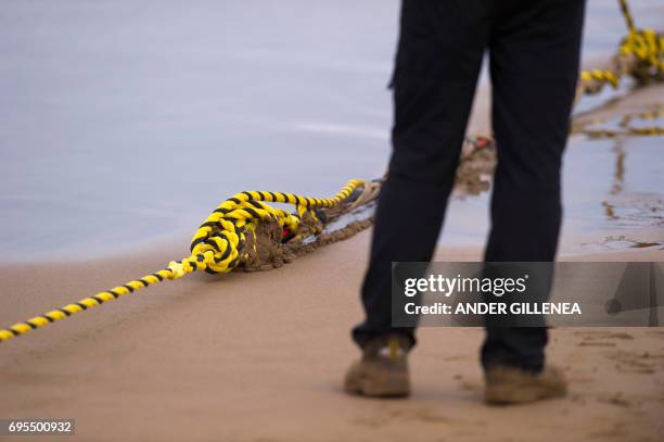An employee stands as he lays an undersea fiber optic cable at Arrietara beach near the Spanish Basque village of Sopelana on June 13, 2017. Facebook...