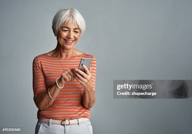 connected to everyone and everything - senior woman studio stock pictures, royalty-free photos & images