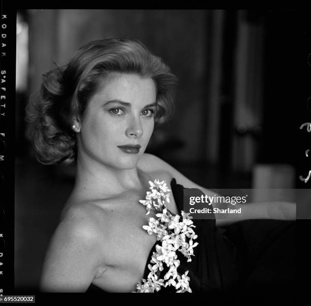 Portrait of American actress Grace Kelly in a strapless gown with a sprig of flowers tucked into her bodice, Hollywood, California, March 1954.