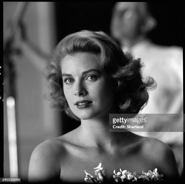 Portrait of American actress Grace Kelly in a strapless gown with a sprig of flowers tucked into her bodice, Hollywood, California, March 1954.