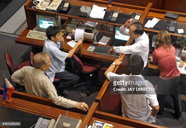 Traders chat during a trading session at the Philippine Stock Exchange in Manila's suburban financial district of Makati on September 10, 2008....
