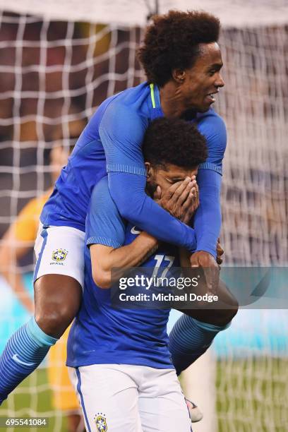 Willian jumps on top of Taison Freda of Brazil who celebrates a goal during the Brasil Global Tour match between Australian Socceroos and Brazil at...