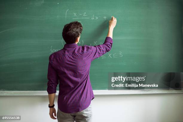 student writing on blackboard - mathematical symbol stock photos et images de collection