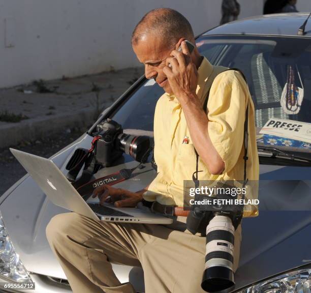 Press photographer Mohamed Hammi sends pictures for his agency on May 25, 2010 in Tunis. / AFP PHOTO / Fethi Belaid