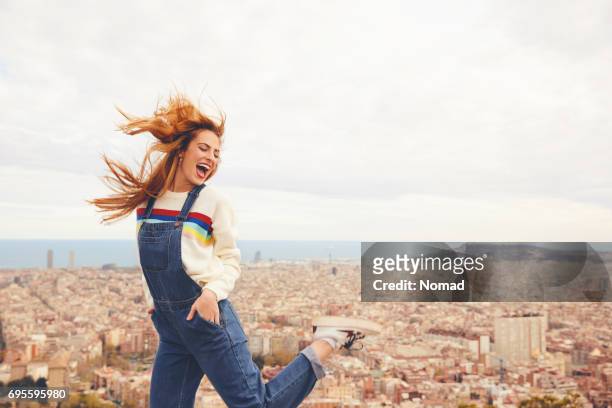 性格開朗的年輕女子跳舞對城市景觀 - bib overalls 個照片及圖片檔