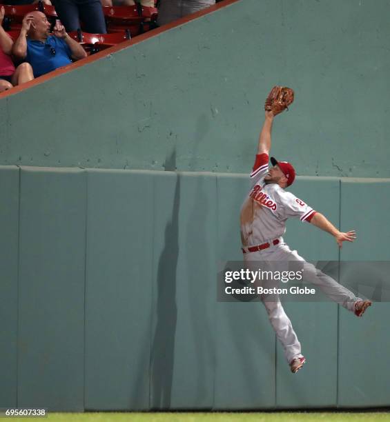 With a potentially game-winning Red Sox run on second base, Phillies left fielder Daniel Nava makes a leaping catch on a fly ball hit by Jackie...