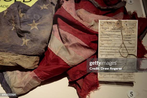 New York City Police Department death certificate and an American flag recovered at Ground Zero are displayed at new 9/11 Tribute Museum, June 13,...