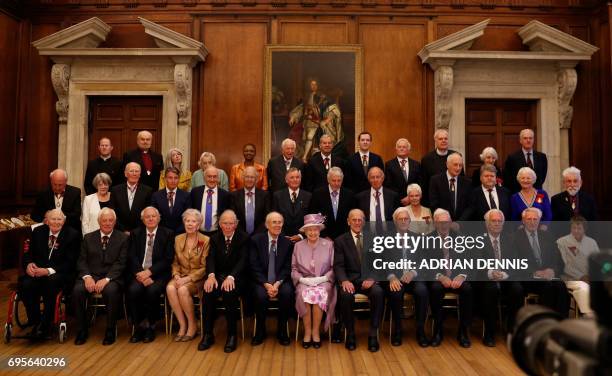 Britain's Queen Elizabeth II sits next to Britain's Prince Philip, Duke of Edinburgh during an official photograph with Companions of Honour after a...