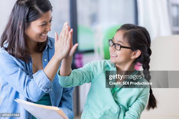 terapeuta físico dar cinco alta a paciente joven - filipino girl fotografías e imágenes de stock