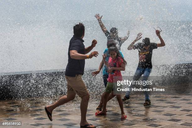 People enjoy during high tide at Worli seaface on June 12, 2017 in Mumbai, India. The much-awaited Southwest Monsoon has finally made an appearance...